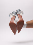 Immagine di scarpe slingback Amina Muaddi Begum in PVC trasparente con decori gioiello, su sfondo neutro.