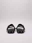 Vista del retro dei sandali Balenciaga in pelle nera con fibbie e borchie argentate.