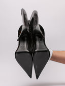 Immagine di stivali alti Balenciaga in pelle lucida nera, silhouette elegante con tacco alto e zip laterale.