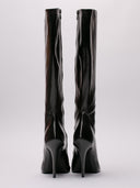 Immagine di stivali alti Balenciaga in pelle lucida nera, silhouette elegante con tacco alto e zip laterale.