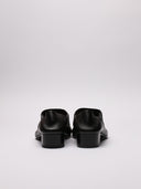 Immagine di scarpe Balenciaga in pelle nera con vista suola ruvida e dettaglio di segno sulla scarpa destra