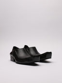 Immagine di scarpe Balenciaga in pelle nera con vista suola ruvida e dettaglio di segno sulla scarpa destra