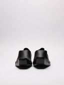 Immagine di scarpe Balenciaga in pelle nera con vista suola ruvida e dettaglio di segno sulla scarpa destra