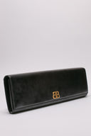Immagine della clutch Balenciaga in pelle lucida con dettagli in metallo dorato. Design elegante e contemporaneo.