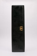 Immagine della clutch Balenciaga in pelle lucida con dettagli in metallo dorato. Design elegante e contemporaneo.