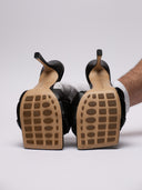 Vista suola del  sandalo Bottega Veneta in pelle nera intrecciata, dettagli su tacco e struttura.