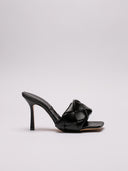 Vista  laterale del sandalo Bottega Veneta in pelle nera intrecciata, dettagli su tacco e struttura.