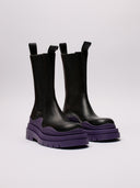 Stivali Bottega Veneta in pelle nera con suola viola, vista laterale e frontale.