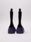 Stivali Bottega Veneta in pelle nera con suola viola, vista laterale e frontale.