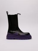 Stivali Bottega Veneta in pelle nera con suola viola, vista laterale e frontale.