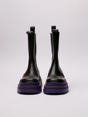 Stivali Bottega Veneta in pelle nera con suola viola, vista laterale e frontale.