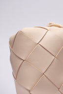 Dettaglio della trama in pelle intrecciata di una borsa Bottega Veneta con lieve ammaccatura.