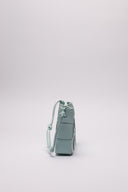Borsa in pelle intrecciata di colore azzurro, vista laterale, evidenziata da dettagli artigianali.