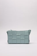 Borsa in pelle intrecciata di colore azzurro, vista frontale, evidenziata da dettagli artigianali.