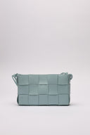 Borsa in pelle intrecciata di colore azzurro, vista posteriore, evidenziata da dettagli artigianali.