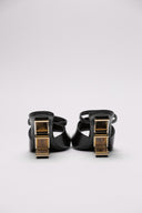 Sandali Fendi in pelle nera con tacco in metallo dorato.