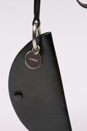 Accessorio Jil Sander in pelle nera con dettagli metallici.
