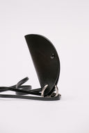 Accessorio Jil Sander in pelle nera con dettagli metallici.