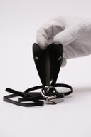 Accessorio Jil Sander in pelle nera con dettagli metallici.