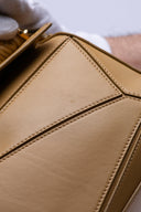 Vista frontale e dettagliata della LOEWE Puzzle Bag in pelle color neutro, con micro segni impercettibili.