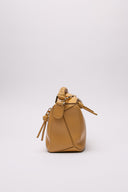 Vista laterale della LOEWE Puzzle Bag in pelle color neutro, con micro segni impercettibili.
