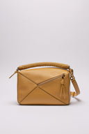 Vista posteriore e dettagliata della LOEWE Puzzle Bag in pelle color neutro, con micro segni impercettibili.