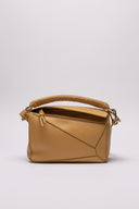 Vista frontale e dettagliata della LOEWE Puzzle Bag in pelle color neutro, con micro segni impercettibili.
