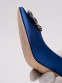 Manolo Blahnik décolleté in satin blu con fibbia, vista laterale e dettagli di fabbricazione.