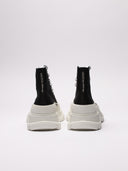 Sneakers alte di MCQUEEN in tela nera con suola bianca robusta, dettagli del retro