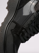 Primo piano di sneakers Off-White nere con dettagli in suede e suola dentellata