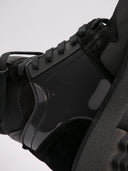 Primo piano di sneakers Off-White nere con dettagli in suede e suola dentellata