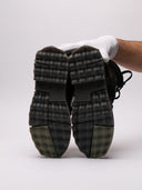 Primo piano di sneakers Off-White nere con dettagli in suede e suola dentellata