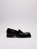 Mocassino RAF SIMONS in pelle lucida nera, vista laterale.