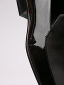 Raffinate slippers Saint Laurent in vernice nera con dettaglio elegante.
