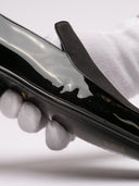 Raffinate slippers Saint Laurent in vernice nera con dettaglio elegante.