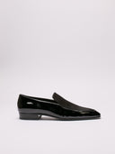 Raffinate slippers Saint Laurent in vernice nera con dettaglio elegante.