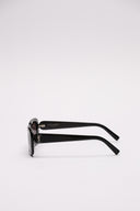 Occhiali da sole SAINT LAURENT in acetato nero con lenti scure e logo YSL laterale.