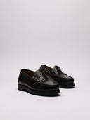 Mocassino VISVIM nero in pelle con logo, vista laterale diagonale
